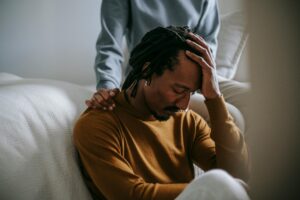man grieving with support of therapist